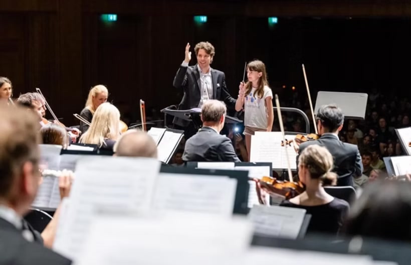 Junge Dirigentin vor dem Orchester