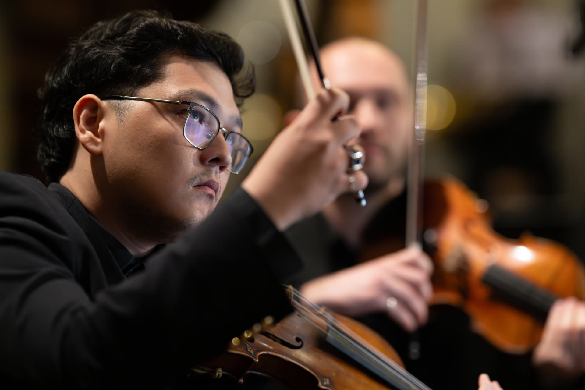 Geiger des Empyrean Orchestra mit erhobenem Bogen