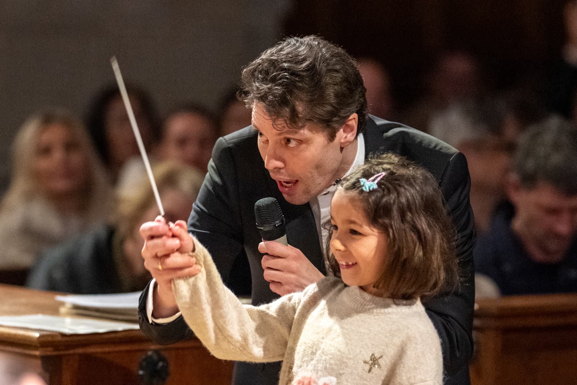 Kevin Griffiths lässt ein Kind das Orchester dirigieren